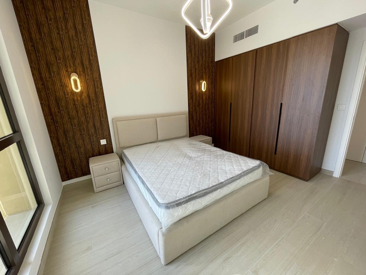 Modern Bedroom with Grey Bed and Wooden Accent Wall